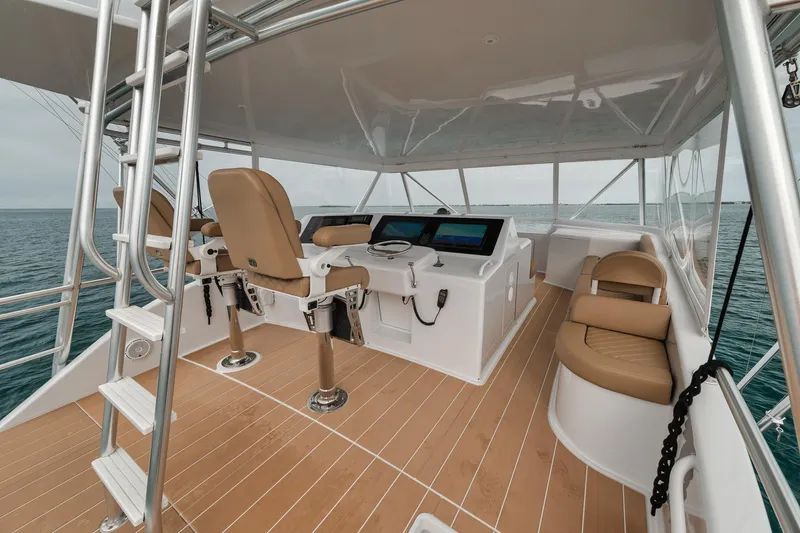 Slide: The Image of Helm of 2001 Viking 65 yacht with modern controls and seating on open water. - 22