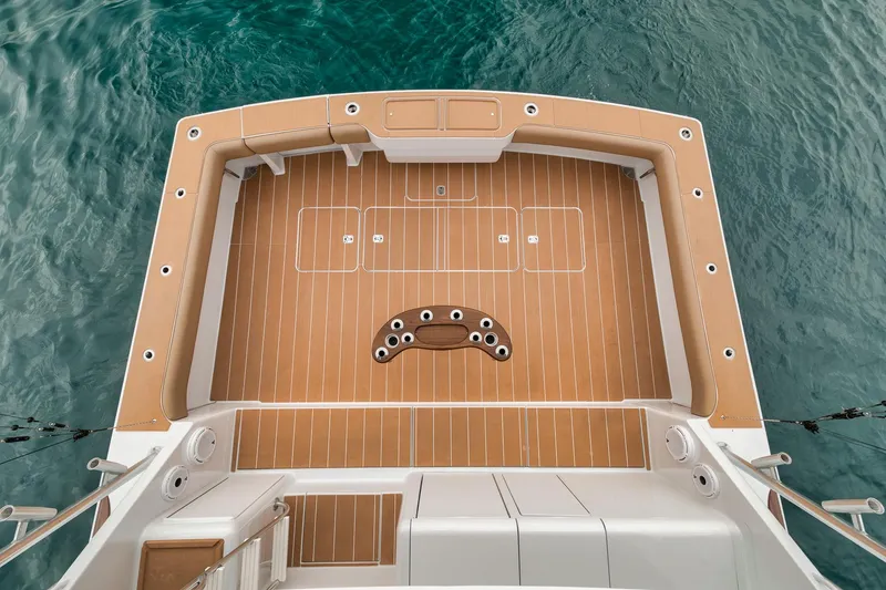 Slide: The Image of 2001 Viking 65 yacht deck with teak flooring, overlooking clear blue water. - 29