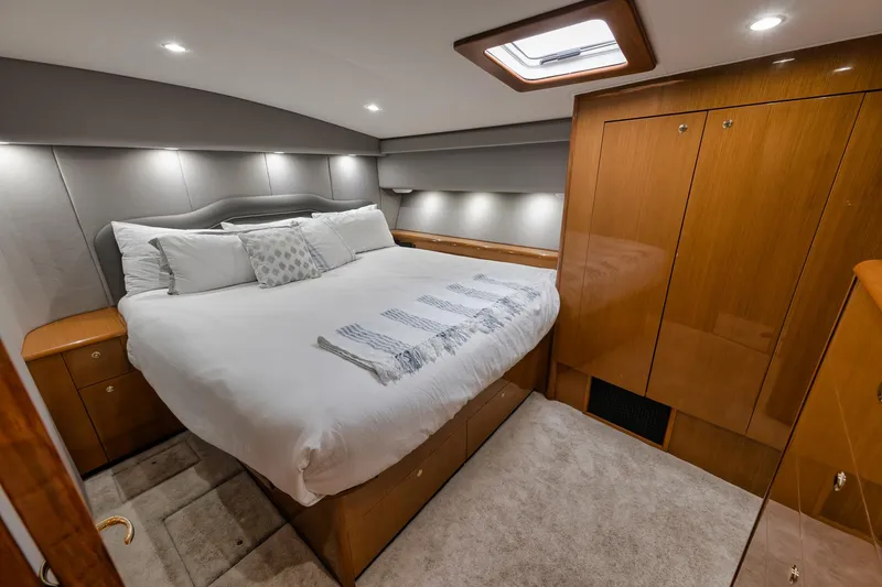 Slide: The Image of Luxurious bedroom interior of a 2001 Viking 65 yacht with elegant wood finishes. - 30