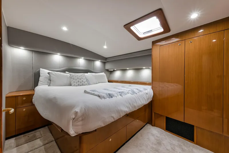 Slide: The Image of Luxurious bedroom interior of a 2001 Viking 65 yacht with elegant wood finishes. - 31