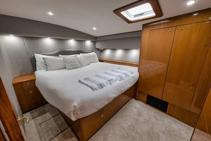 Slide: The Image of Luxurious bedroom interior of a 2001 Viking 65 yacht with elegant wood finishes. - 32