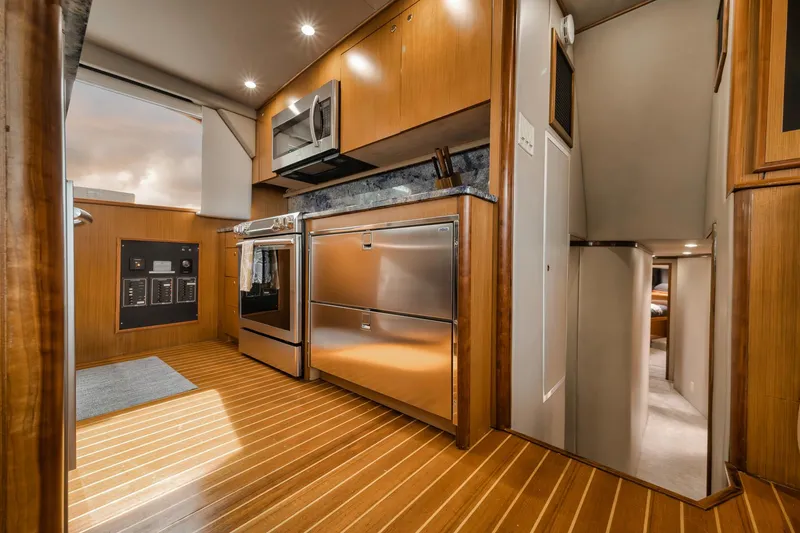 Slide: The Image of Luxurious kitchen interior of a 2001 Viking 65 yacht with modern appliances and wood flooring. - 47