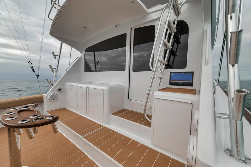 Slide: The Image of 2001 Viking 65 yacht deck with seating, ladder, and ocean view. - 48