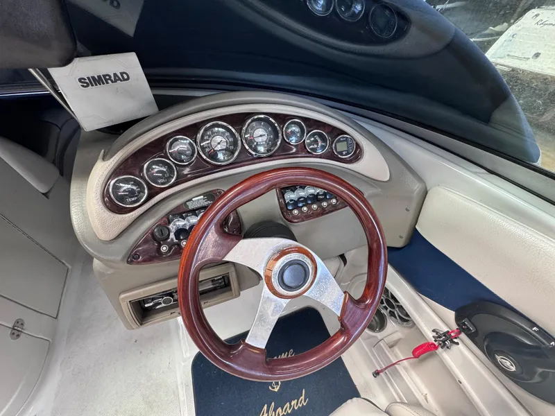 Slide: The Image of 2011 Crownline 245 SS boat dashboard with wood steering wheel and Simrad navigation system. - 10