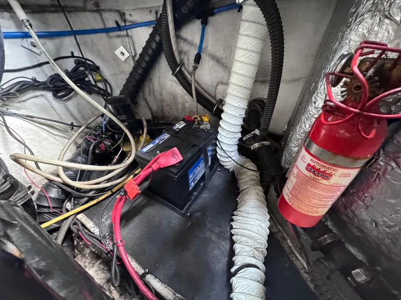 Slide: The Image of Engine compartment of a 2011 Crownline 245 SS boat with battery and fire extinguisher. - 13