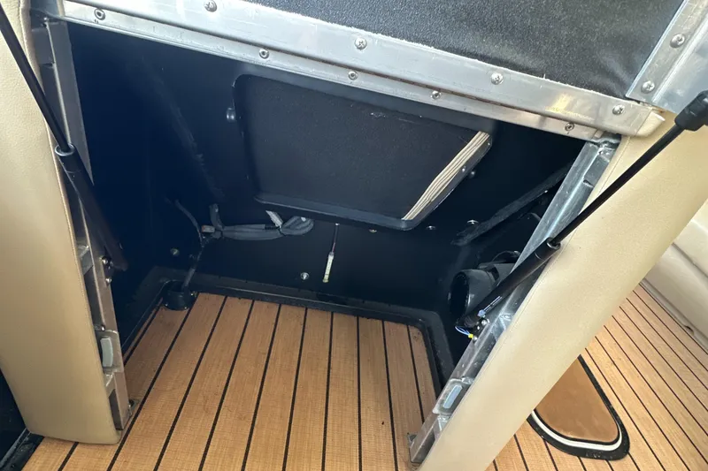 Slide: The Image of 2019 Harris Solstice 240 boat interior storage compartment with wooden flooring. - 30