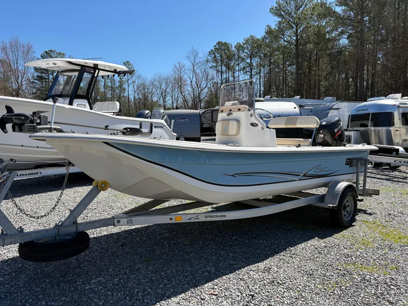 Slide: The Image of 2017 Carolina Skiff 18JVX boat on trailer, parked outdoors with trees in background. - 1