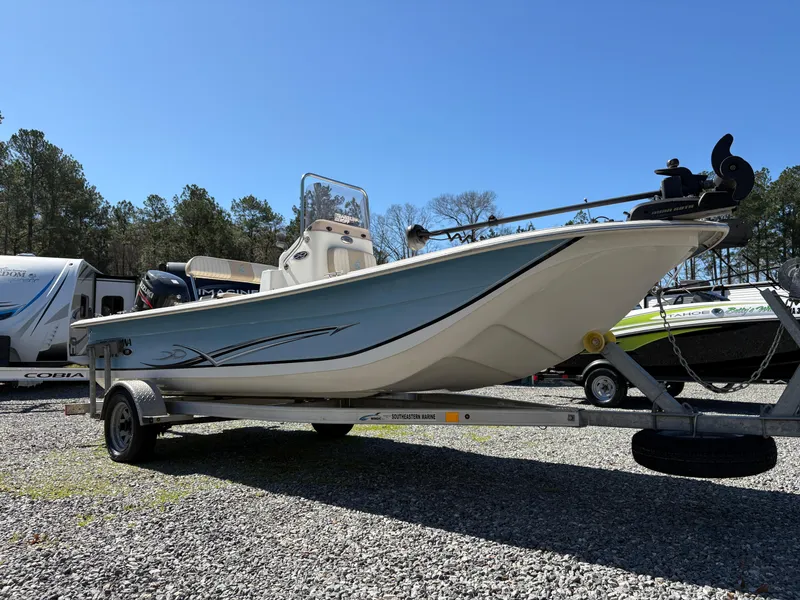 Slide: The Image of 2017 Carolina Skiff 18JVX boat on trailer, parked outdoors under clear blue sky. - 4