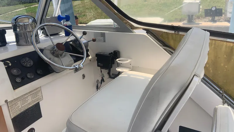 Slide: The Image of 1987 Luhrs Alura 30 boat cockpit with steering wheel and controls. - 11