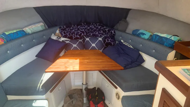 Slide: The Image of 1987 Luhrs Alura 30 cabin interior with cozy seating and wooden table. - 13