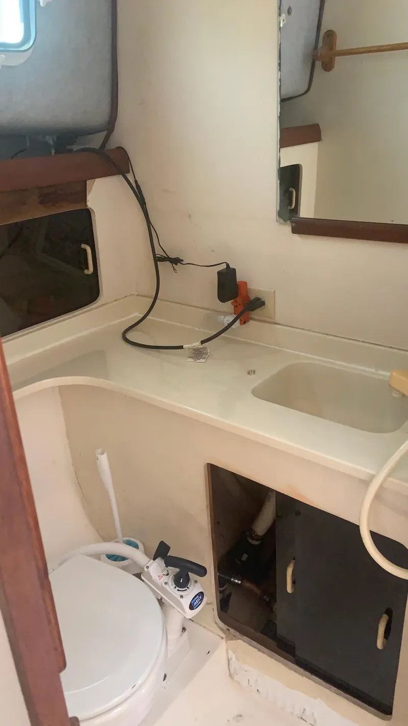 Slide: The Image of 1987 Luhrs Alura 30 boat bathroom with sink, mirror, and toilet. - 17