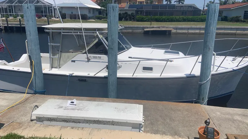 Slide: The Image of 1987 Luhrs Alura 30 boat docked at a marina, side view. - 4