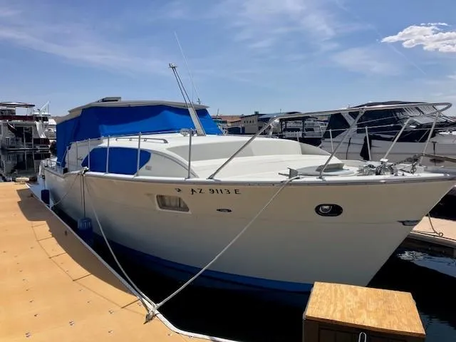 Slide: The Image of 1969 Chris-Craft Commander boat docked with blue canopy under clear sky. - 3