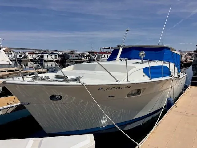 Slide: The Image of 1969 Chris-Craft Commander boat docked at a marina with blue canopy. - 4