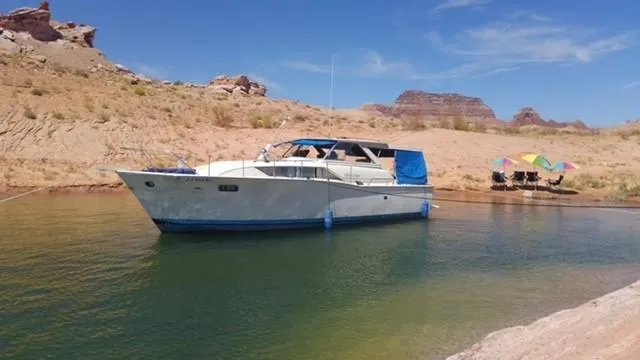 Slide: The Image of 1969 Chris-Craft Commander boat anchored in a scenic desert lake setting. - 7