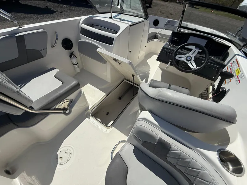 Slide: The Image of 2022 Bayliner VR6 Bowrider OB interior with seating, steering wheel, and storage compartment. - 15