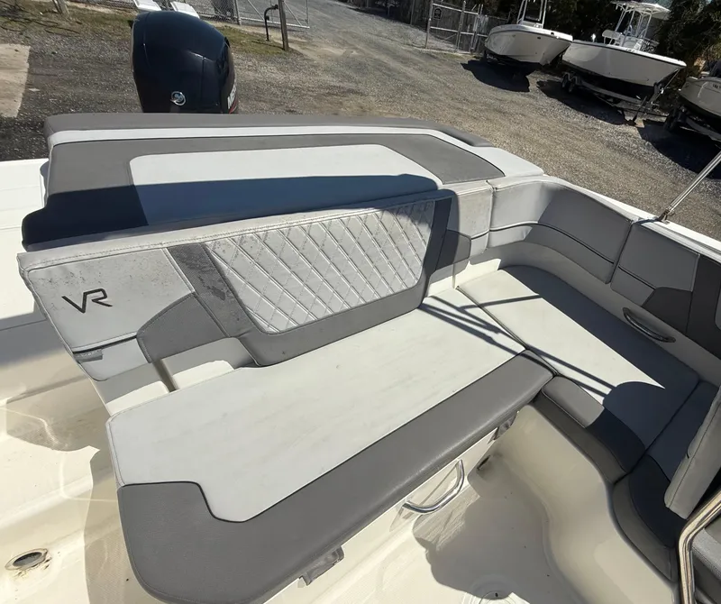 Slide: The Image of 2022 Bayliner VR6 Bowrider OB interior seating with gray upholstery and VR logo. - 16