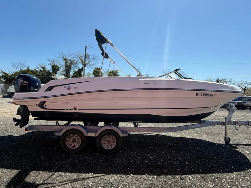 Slide: The Image of 2022 Bayliner VR6 Bowrider OB on trailer, side view, outdoors under clear sky. - 6