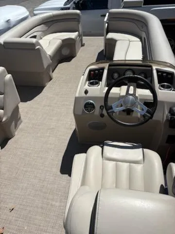 Slide: The Image of 2019 Bennington 22SLX pontoon boat interior with beige seating and steering console. - 9