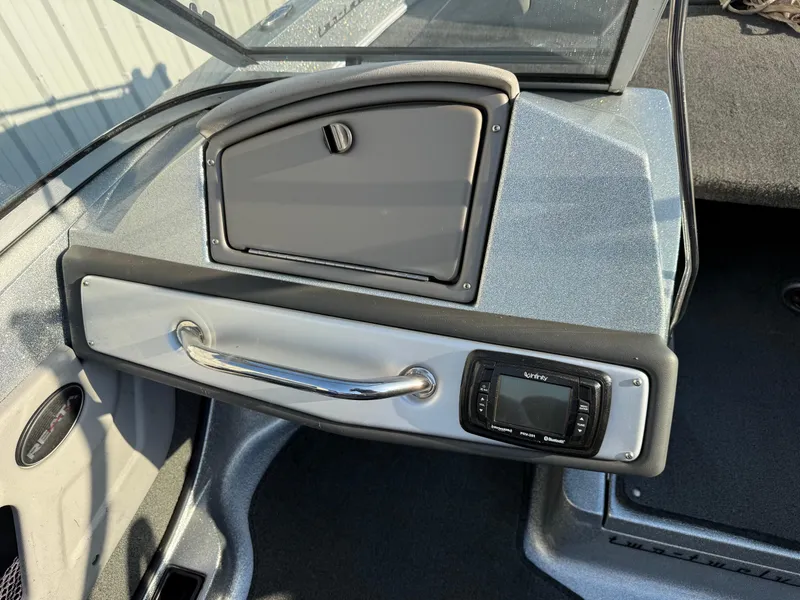 Slide: The Image of 2017 Ranger 212LS Reatta boat dashboard with storage compartment and control panel. - 10