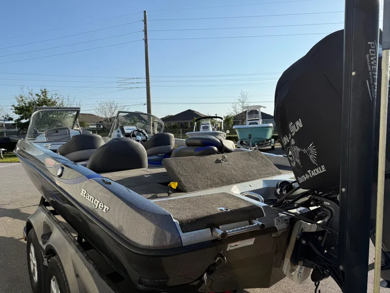 Slide: The Image of 2017 Ranger 212LS Reatta boat parked outdoors, showcasing seating and motor. - 13