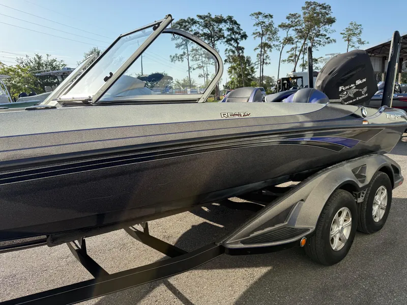 Slide: The Image of 2017 Ranger 212LS Reatta boat on trailer, sleek design, parked outdoors. - 4