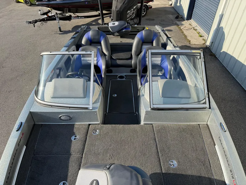 Slide: The Image of 2017 Ranger 212LS Reatta boat with dual windshields and seating, parked outdoors. - 6