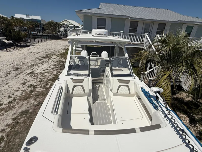 Slide: The Image of 2021 World Cat 280 DC-X boat with dual engines on a trailer, under clear blue sky. - 12
