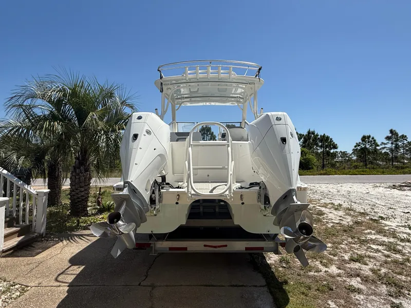 Slide: The Image of 2021 World Cat 280 DC-X boat on trailer under clear blue sky. - 2