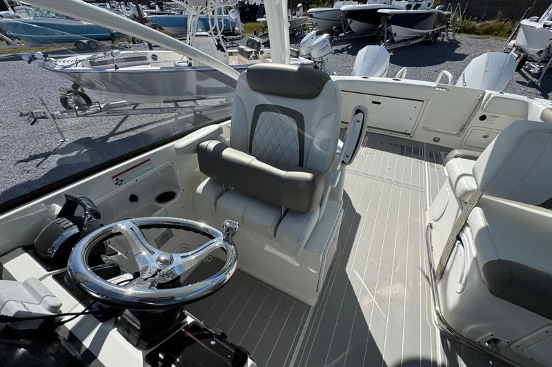 Slide: The Image of 2021 World Cat 280 DC-X boat interior with steering wheel and seating. - 21