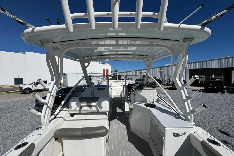 Slide: The Image of 2021 World Cat 280 DC-X boat interior with seating and helm, docked under clear blue sky. - 30