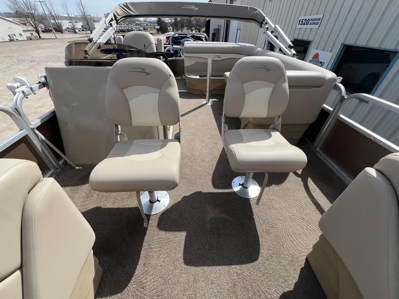 Slide: The Image of 2012 Bennington 24 SL pontoon boat interior with beige seating and carpet. - 11