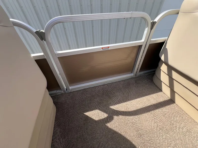 Slide: The Image of Interior view of a 2012 Bennington 24 SL pontoon boat with beige seating and carpet. - 12