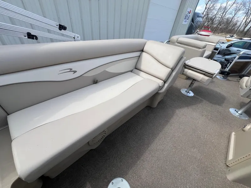 Slide: The Image of 2012 Bennington 24 SL pontoon boat interior with beige seating and carpeted floor. - 13