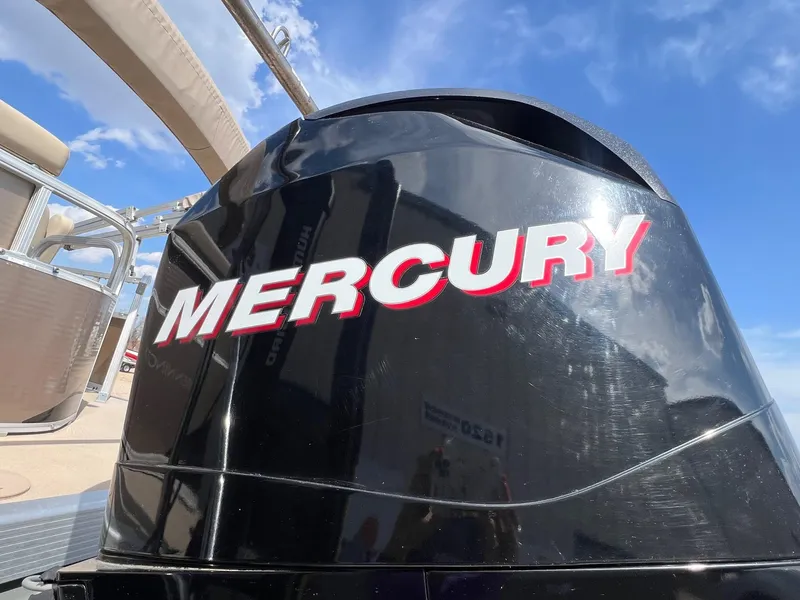 Slide: The Image of Mercury outboard motor on a 2012 Bennington 24 SL pontoon boat under a clear blue sky. - 4