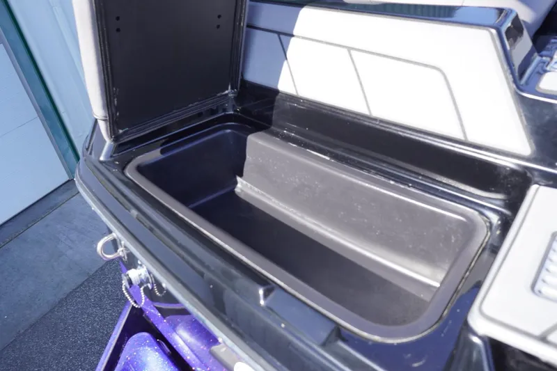 Slide: The Image of 2022 Malibu Wakesetter 23 LSV storage compartment, open and empty, with sleek black interior. - 15