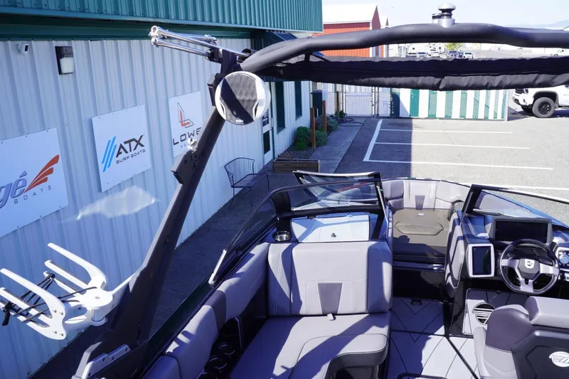 Slide: The Image of 2022 Malibu Wakesetter 23 LSV boat interior with seating and control panel in a marina setting. - 40