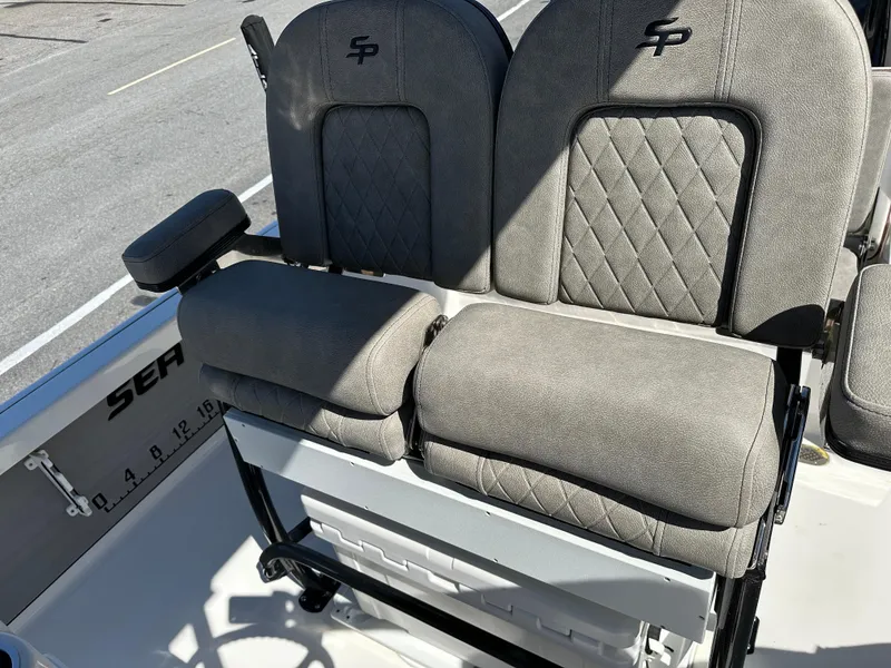 Slide: The Image of 2022 Sea Pro 248 DLX boat seats with quilted gray upholstery and armrest. - 12