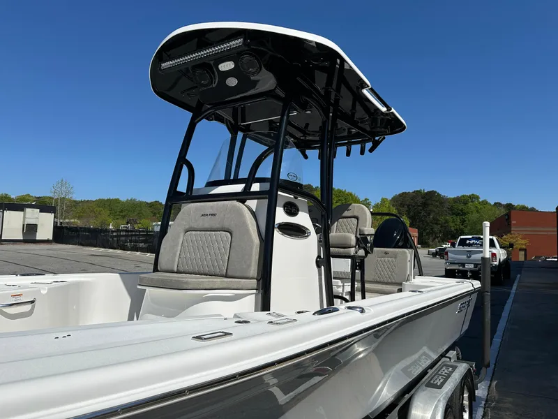 Slide: The Image of 2022 Sea Pro 248 DLX boat with T-top, parked outdoors on a sunny day. - 6