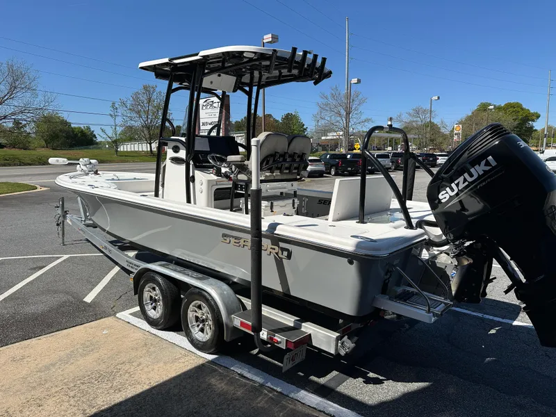 Slide: The Image of 2022 Sea Pro 248 DLX boat on trailer with Suzuki outboard motor, parked outdoors. - 7