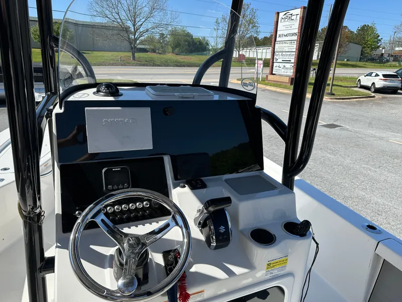 Slide: The Image of 2022 Sea Pro 248 DLX boat dashboard with steering wheel and controls. - 9