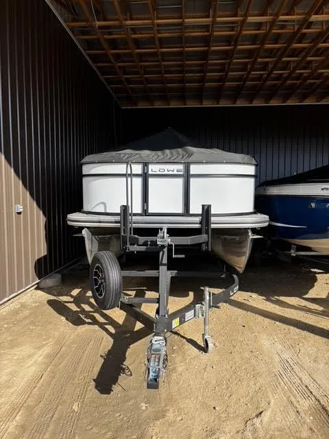 Slide: The Image of 2025 Lowe LS210 boat on trailer in covered storage area. - 1