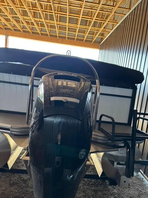 Slide: The Image of Lowe LS210 boat with Mercury 115 engine in a covered storage area, 2025 model. - 4