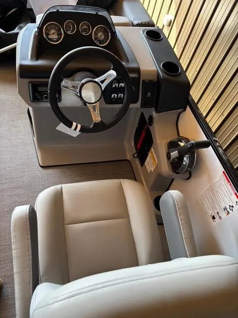 Slide: The Image of 2025 Lowe LS210 boat cockpit with steering wheel, gauges, and comfortable seating. - 9