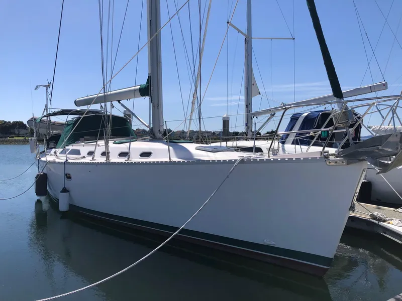 The Image of 2002 Catalina 470 sailboat docked in calm waters under clear blue sky. - 0