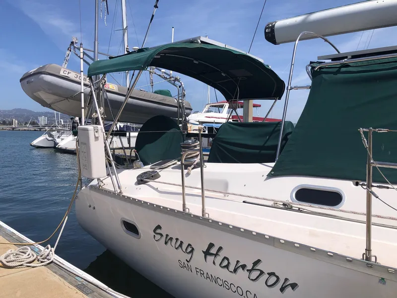 Slide: The Image of Catalina 470 sailboat docked, featuring green canopy and "Snug Harbor" text. - 28