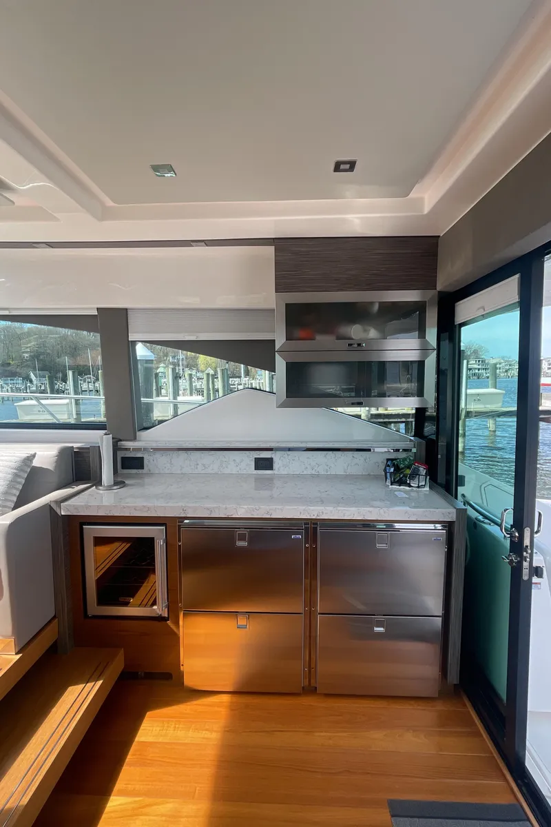 Slide: The Image of 2020 Tiara Yachts 53 Coupe interior kitchen with modern appliances and waterfront view. - 12