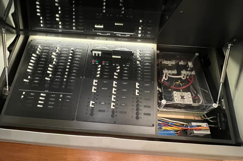 Slide: The Image of Electrical control panel inside a 2020 Tiara Yachts C53 Coupe, showcasing switches and wiring. - 17