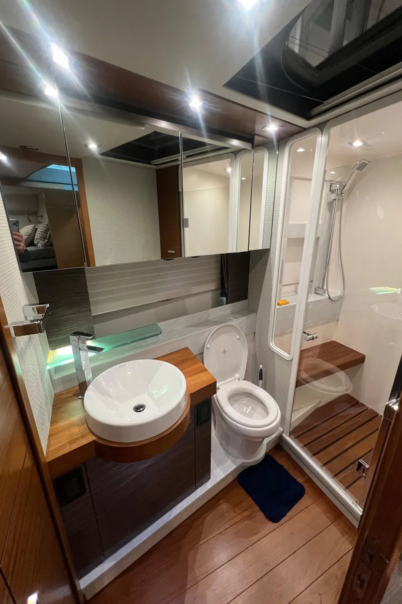 Slide: The Image of Luxurious bathroom in 2020 Tiara Yachts C53 Coupe with modern fixtures and wooden accents. - 23