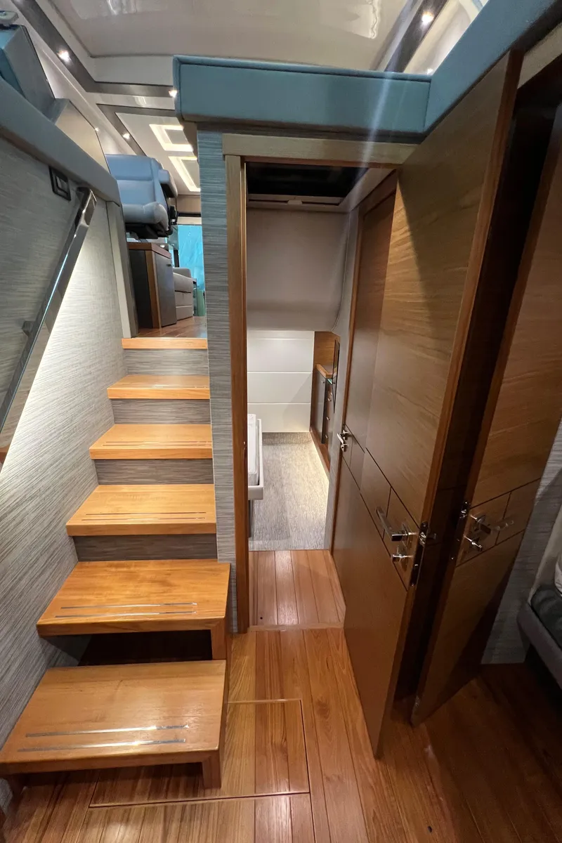 Slide: The Image of Interior of 2020 Tiara Yachts C53 Coupe, featuring wooden stairs and modern design. - 24